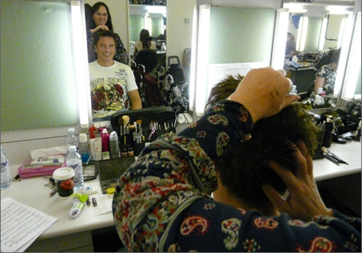 John in hair and makeup, his music sitting nearby.